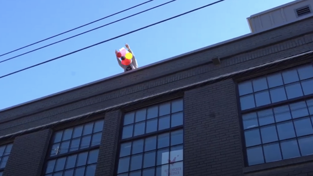 Person on a roof participating in an egg drop challenge